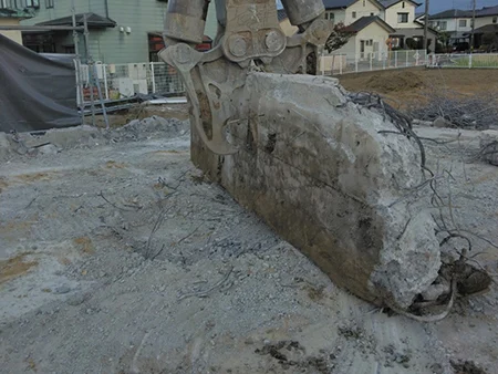富山の解体工事屋　株式会社エイキ　二階建てRC造解体　解体された基礎の一部を重機で掴む