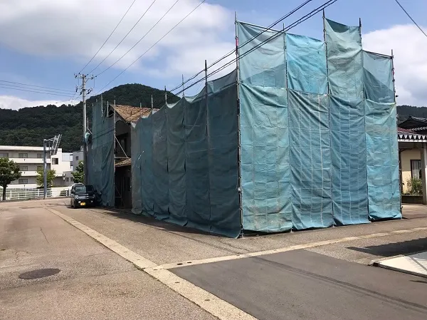 解体する構築物を覆う養生シート