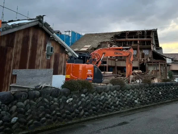 富山の株式会社エイキ　長年の歴史息づく木造解体工事　ユンボによる解体工事中