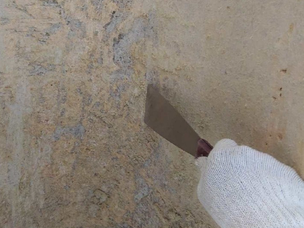 スクレーパーで煙突断熱材の除去している様子