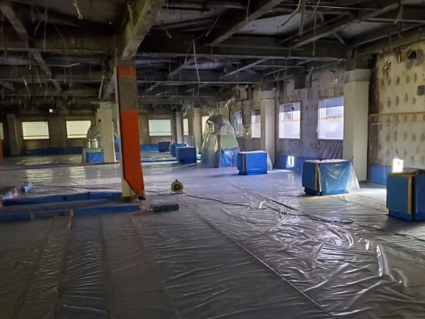 富山の薬品工場でのレベル1アスベスト除去。ビニールシートでの隔離養生作業と負圧除塵装置を設置している最中の写真