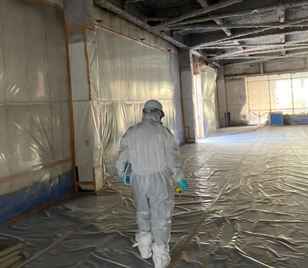 富山の株式会社エイキ(EIKI Inc.)の作業員が、アスベストの現場で養生の点検調査をしている様子