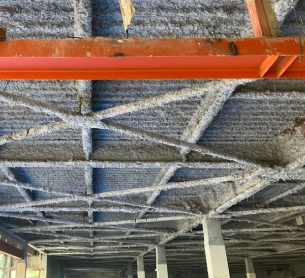 富山のレベル1アスベスト除去現場。赤い鉄骨の上に吹き付けられているアスベスト