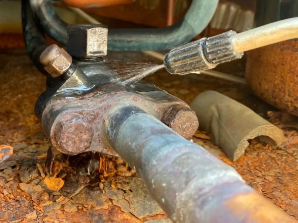 富山でレベル3小型パッキンのアスベスト除去。細い配管のアスベスト含有パッキンに薬剤をかけて湿潤化している最中の写真