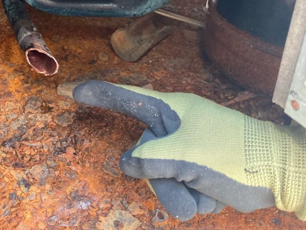 富山でレベル3小型パッキンのアスベスト除去。株式会社エイキの作業員がアスベストパッキンの除去後、指差しで確認している最中の写真。