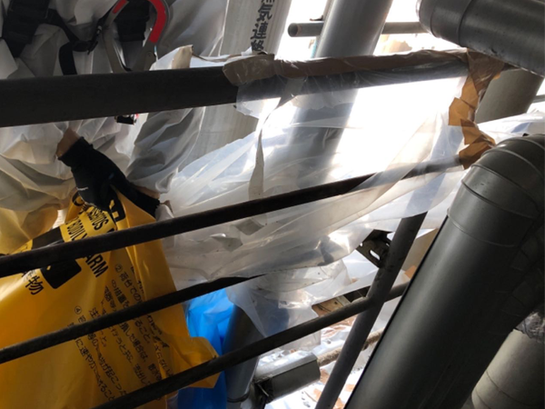 グローブバッグを配管から取り外している様子