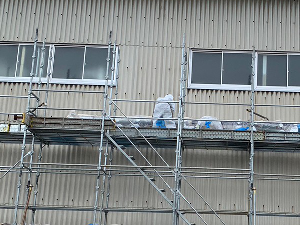 グローブバッグ内の配管からアスベスト保温材を除去している様子