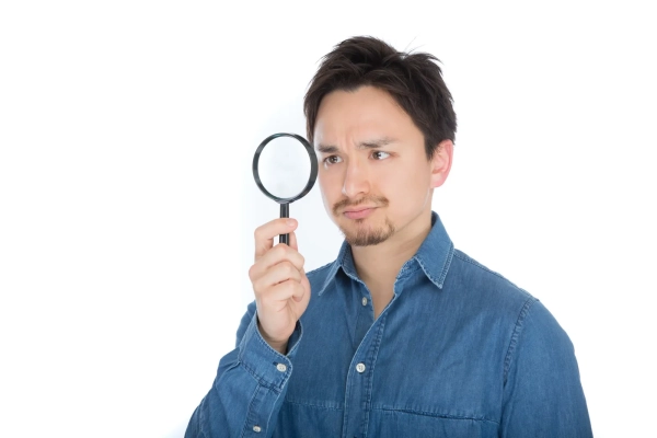 虫眼鏡を構える男性