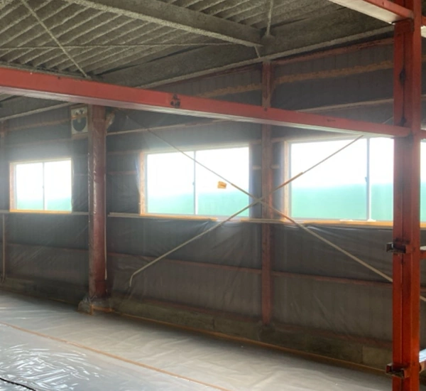 倉庫の吹き付けアスベストを除去するために、現場を養生している様子