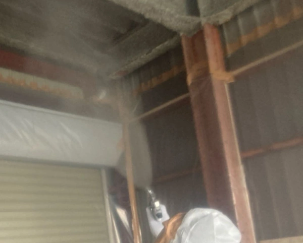 天井の吹き付けアスベストが飛散しないように、飛散抑制剤を散布している様子