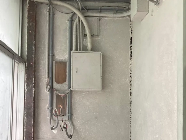 石川県のアスベスト除去現場。電気メーターが取り外され、壁のアスベスト材もグラインダーで除去された後の写真。