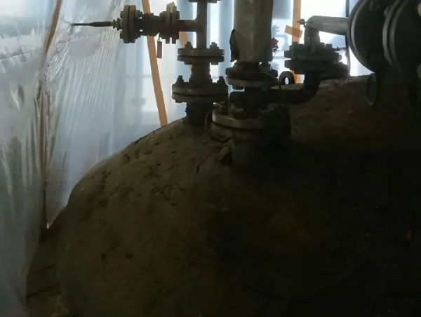 富山の工場でタンク上部のアスベスト断熱（保温剤）除去。　株式会社エイキの作業員が除去前のタンクを撮影