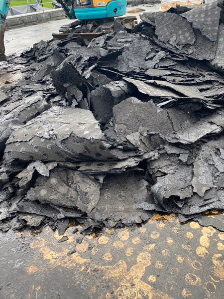 剥がされたアスファルト材が積み重なっている。