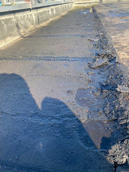 屋上の内周回りのアスファルト防水。左にはパラペットがある。