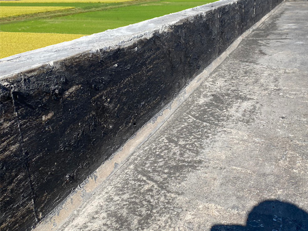 パラペットのアスファルト防水材が撤去されて下地材のみの状態となっている。