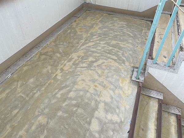 長尺シートが剥がされ、シート施工時の床の跡がざらざらとした質感で露出している。