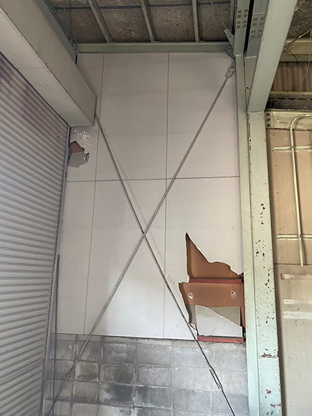 正面には右側が少し欠けたケイ酸カルシウム板の壁があり、左にはシャッターがある