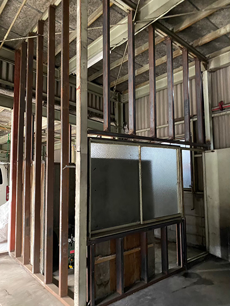 ケイカル板の壁を撤去した小部屋。窓とドアと四方を囲むように並んだ垂直の鉄骨躯体だけが残っている。