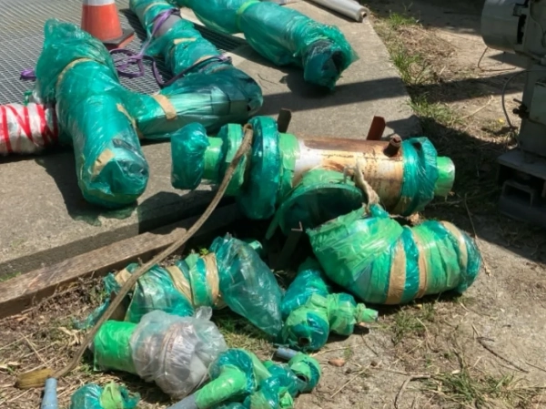 富山でポンプのアスベスト部品を除去。取り外した配管に緑色のシートが巻かれている
