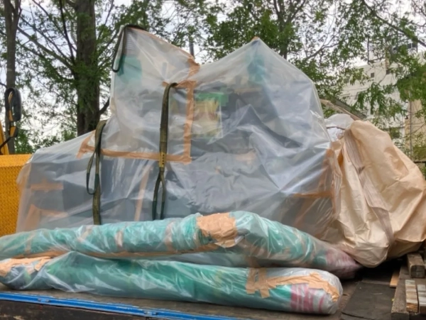 富山でポンプのアスベスト部品を除去。シートに包まれたポンプと配管がトラックの荷台に乗せられている