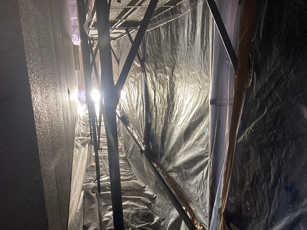 アパートの外壁と隔離養生のシートの間にできた空間