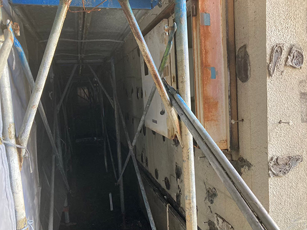 セメント板を取り外し、接着剤と釘が現れたアパート1階の外壁下地