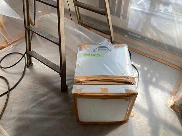 隔離養生内に置かれた脚立と負圧除じん装置