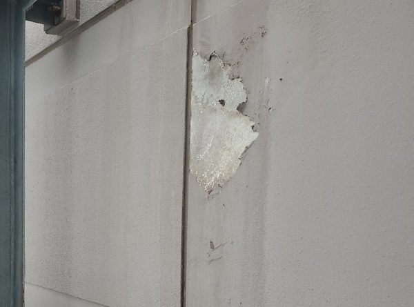 アスベストを含有する外壁塗材が劣化し、剥がれ落ちている様子