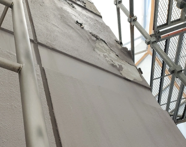 外壁アスベスト除去工事の足場設置後の近影。広範囲に及ぶ仕上げ塗材の剥離。