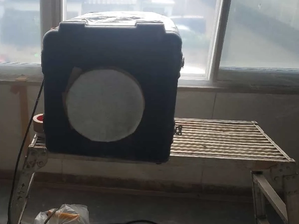 窓のすぐ手間の脚立の上に負圧除塵装置が置かれている