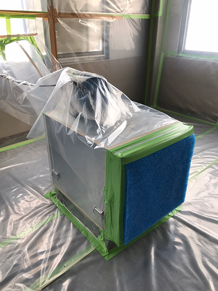 アスベスト除去工事現場の隔離養生に設置された負圧除じん装置。