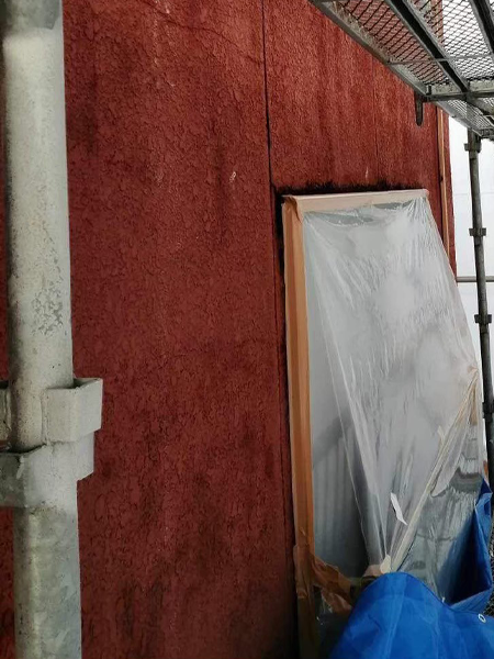 吹き付けアスベスト封じ込め工事前の建物の赤い外壁。