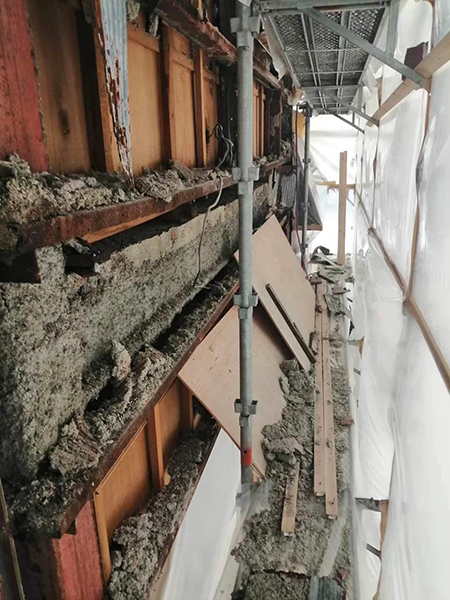 吹き付けアスベストに覆われた鉄骨梁と剥落した吹き付けアスベスト。