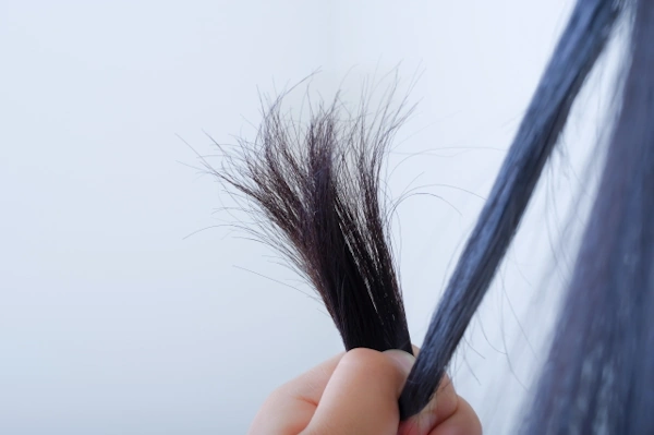 女性が髪の毛をいじっている様子