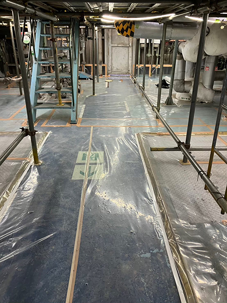 機械室の廊下に負圧隔離養生の為のシートが敷かれている。