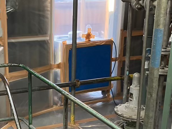 負圧隔離養生と外部の境界に設置されている負圧除じん装置。青い部分がフィルターとなっている