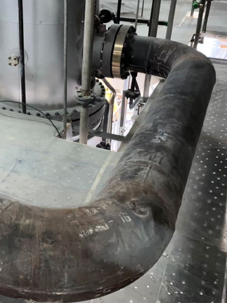 保温材がすべて外されて、何も巻かれていない配管の黒い管。