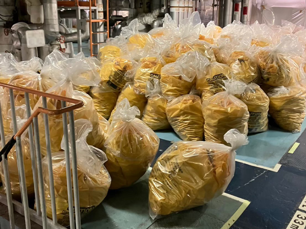 二重梱包された黄色の廃棄袋が一か所にまとめられている。