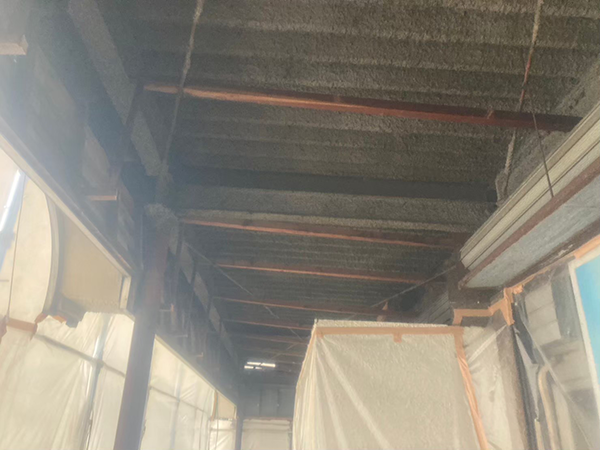 吹き付けアスベストが、屋根裏と鉄骨梁に施工されている1。