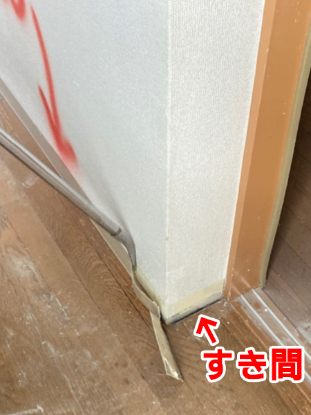壁と床の境目にあったすき間が、バールをアスベスト巾木にさし込んで剥がし際に現れた様子。
