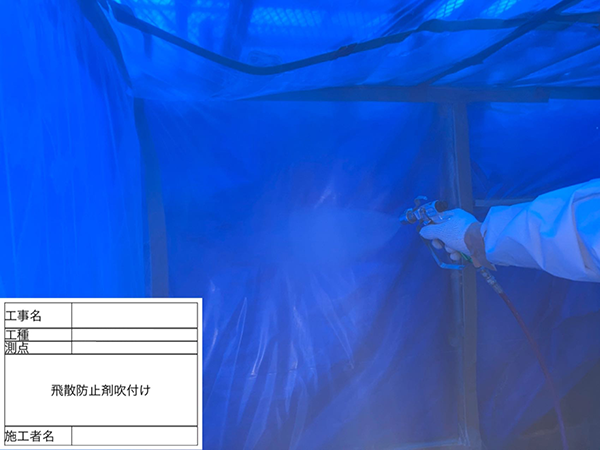 除去作業を終えて隔離養生内のシートに飛散防止剤を噴霧器で散布している様子。