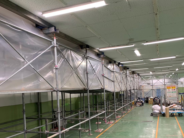 工場内に設置された足場に養生シートが張られ、負圧隔離養生されている。