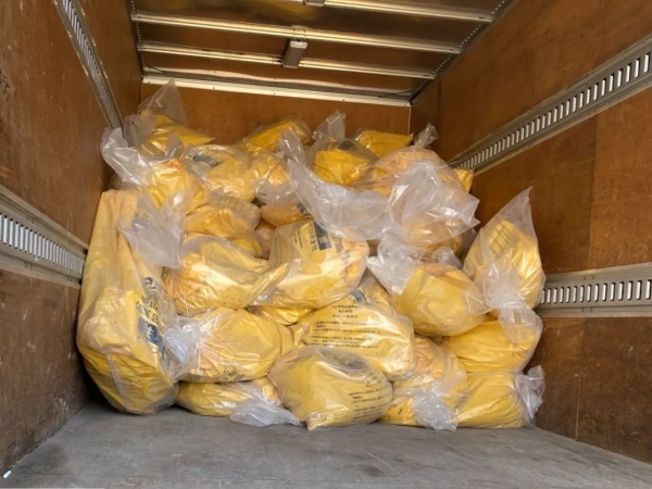 除去後のアスベストと養生等をまとめた二重梱包済みの袋がトラックの荷台に積まれている