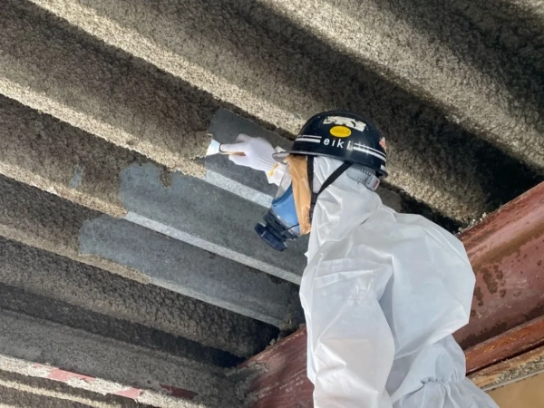 株式会社エイキの作業員がケレンでアスベストをそぎ落としている