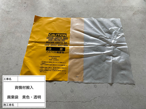 黄色と透明色のアスベスト専用廃棄袋が並んでいる。
