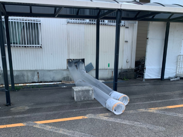 建物の壁から外へと伸びている二本の排気ダクト。
