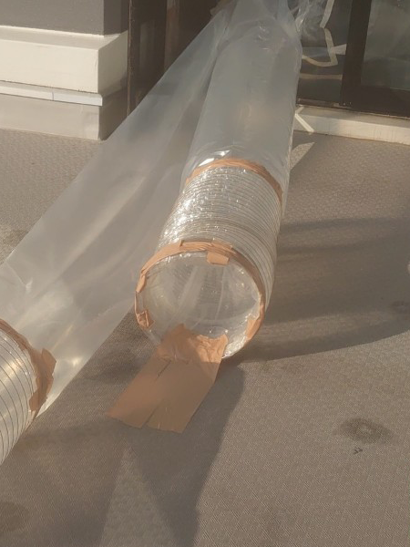 外の排気ダクトの先端にPET製のダクトが接続されている。