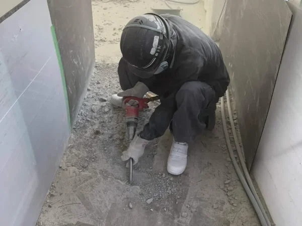 電動ドリルを使って床を斫る