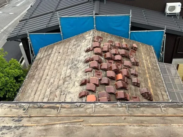 富山県内での解体工事現場で、瓦が外され、屋根下地が露出している写真。