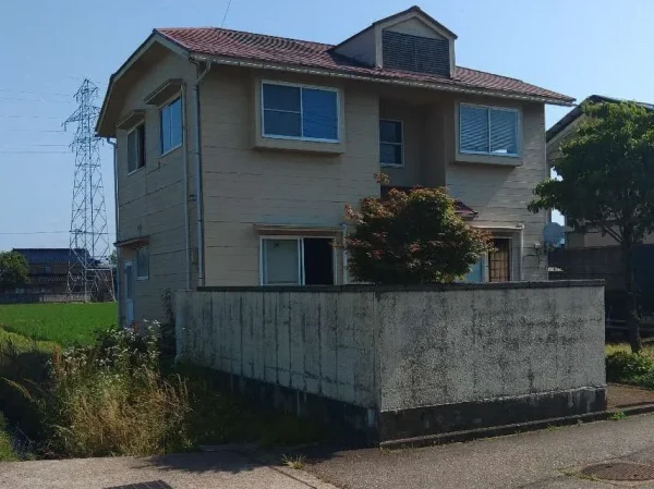 富山の総二階の家です。これから解体する富山の住宅の外観です。ブロック塀が前庭を取り囲んでいます。前庭には、一階の高さを超える樹木が植わっています。